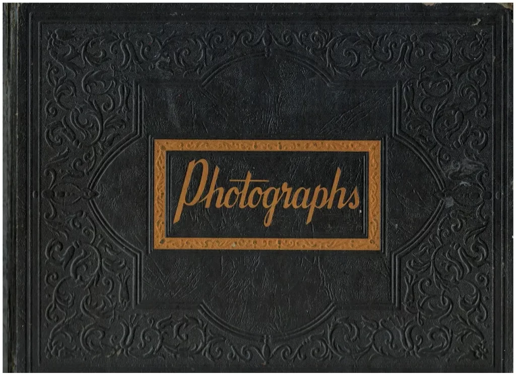 Vinatge black cover Photograph album with gold text saying "Photographs" for Mrugacz family.