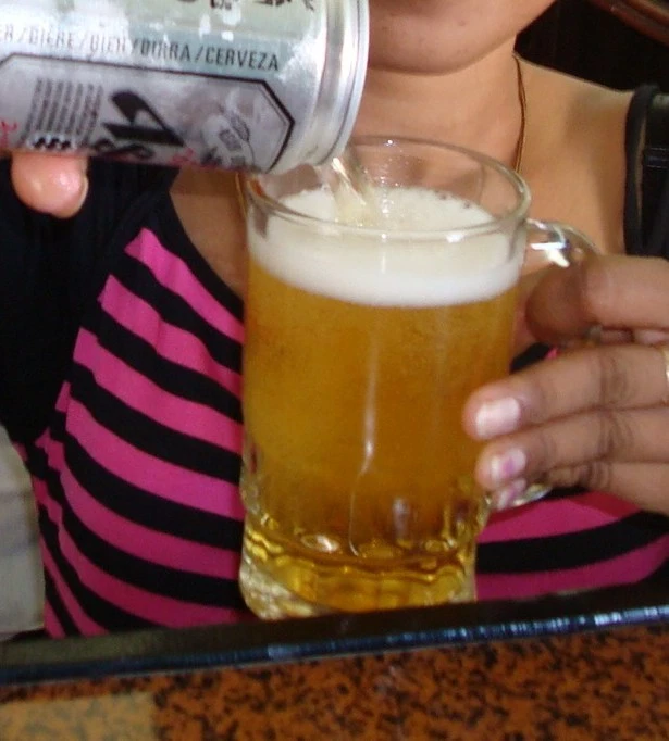 Cambodian woman pouring and serving a beer in Phnom Penh Diary 2007.